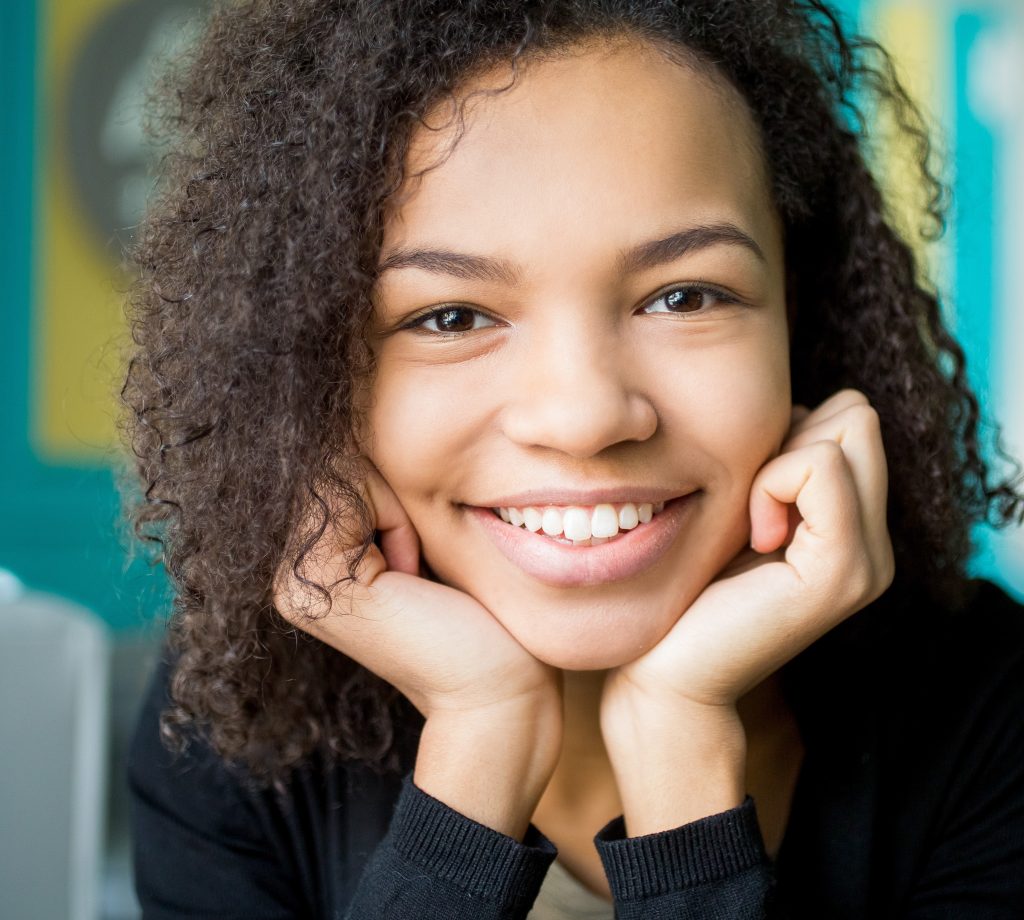 Smiling girl resting head in two hands